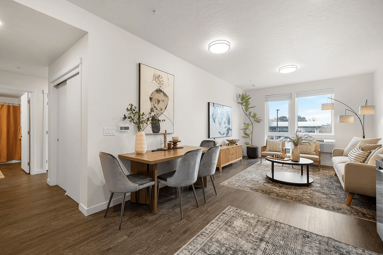 A modern living room with a dining table and chairs.